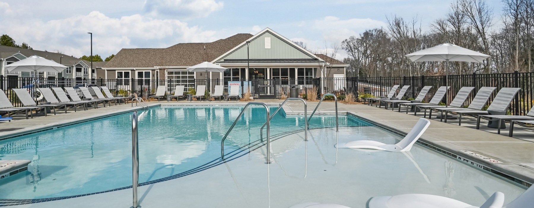 a swimming pool with chairs around it